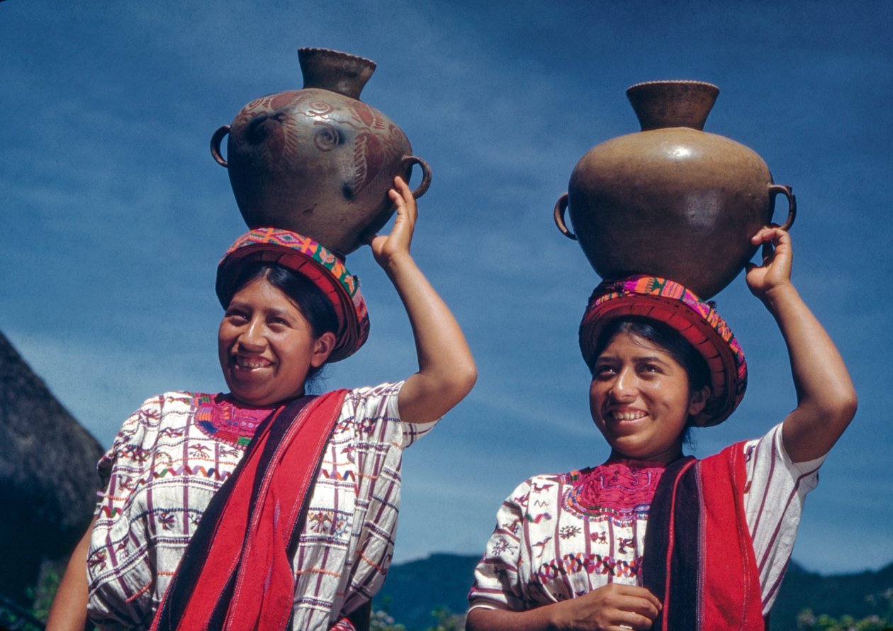 Guatemalan women carrying water jugs in the village of Nebaj, Guatemala by Luis Marden