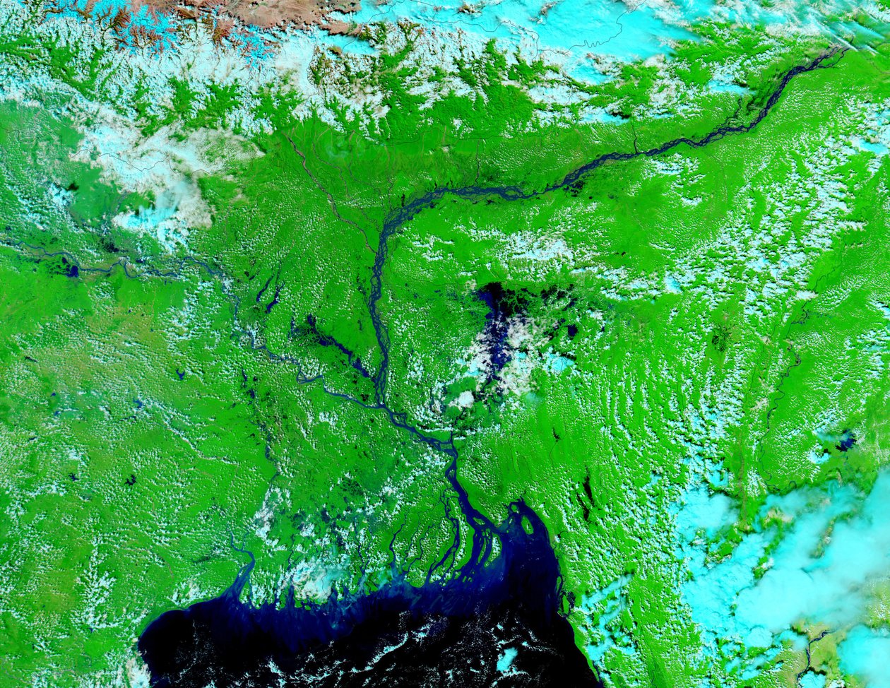 Satellite image, 5 October 2002, showing water-logged lowlands in India and Bangladesh. Bright blue is rivers, lakes and flooded areas. Dark area center foreground is Bay of Bengal by National Aeronautics and Space Administration National Aeronautics and Space Administration