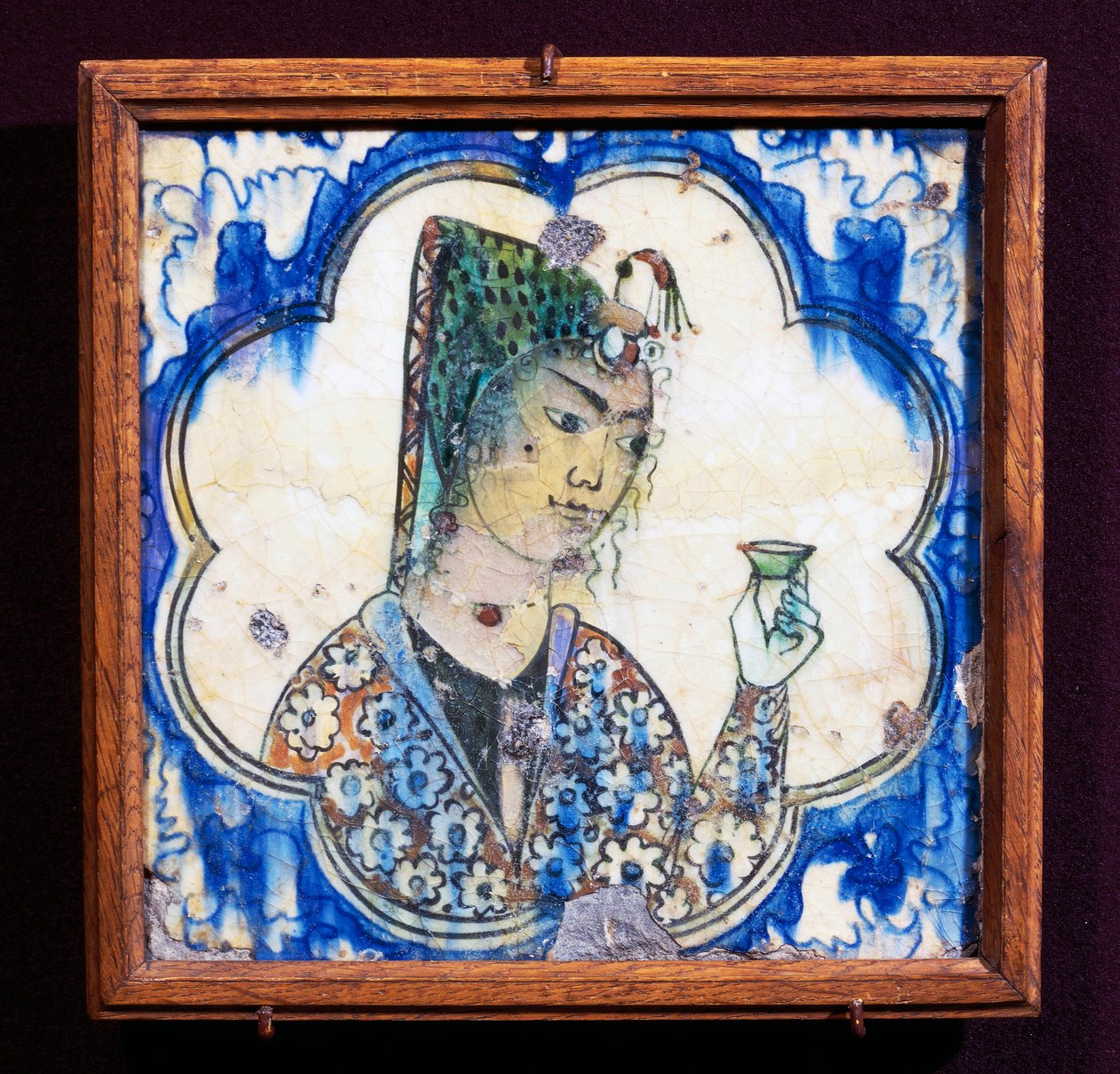Ceramic tile depicting young woman holding vase by Persian School