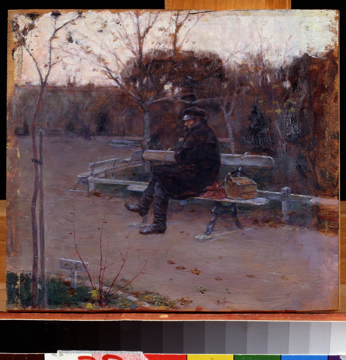 On the Boulevard. A man alone, sitting on a bench in the cold, near him, a bundle and a toolbox. by Peter Alexandrovich Nilus