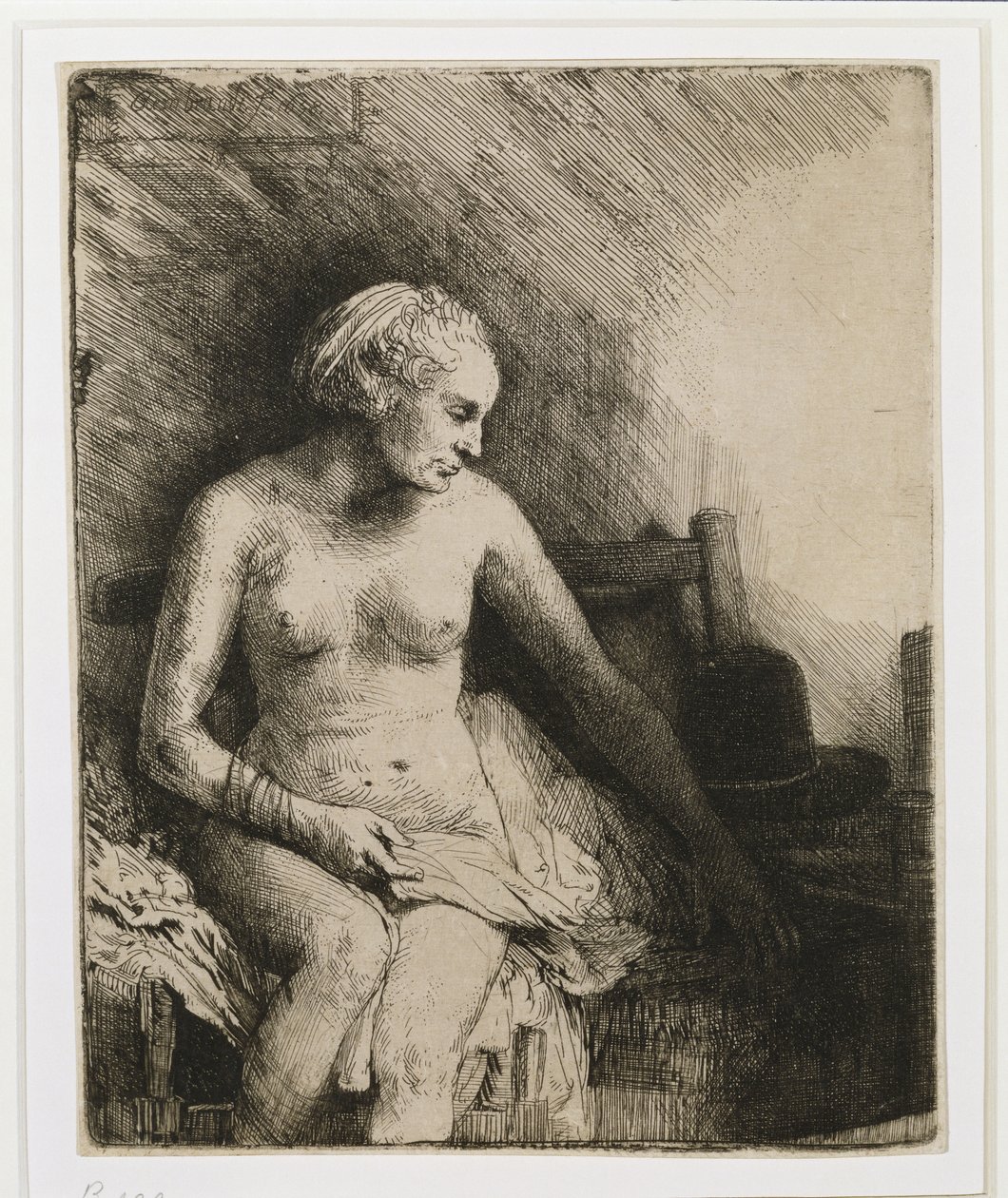 A woman at the bath with a hat beside her by Rembrandt van Rijn