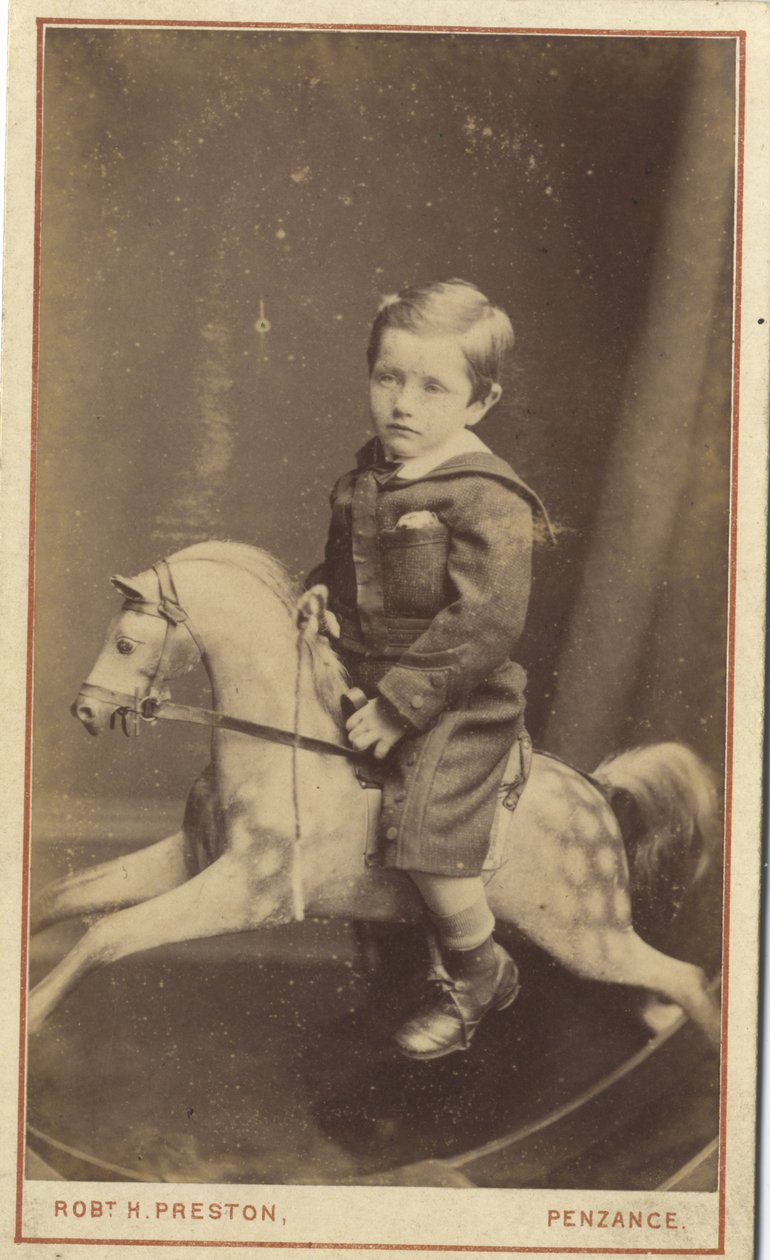 Young boy sitting on a rocking horse by Robert H. Preston