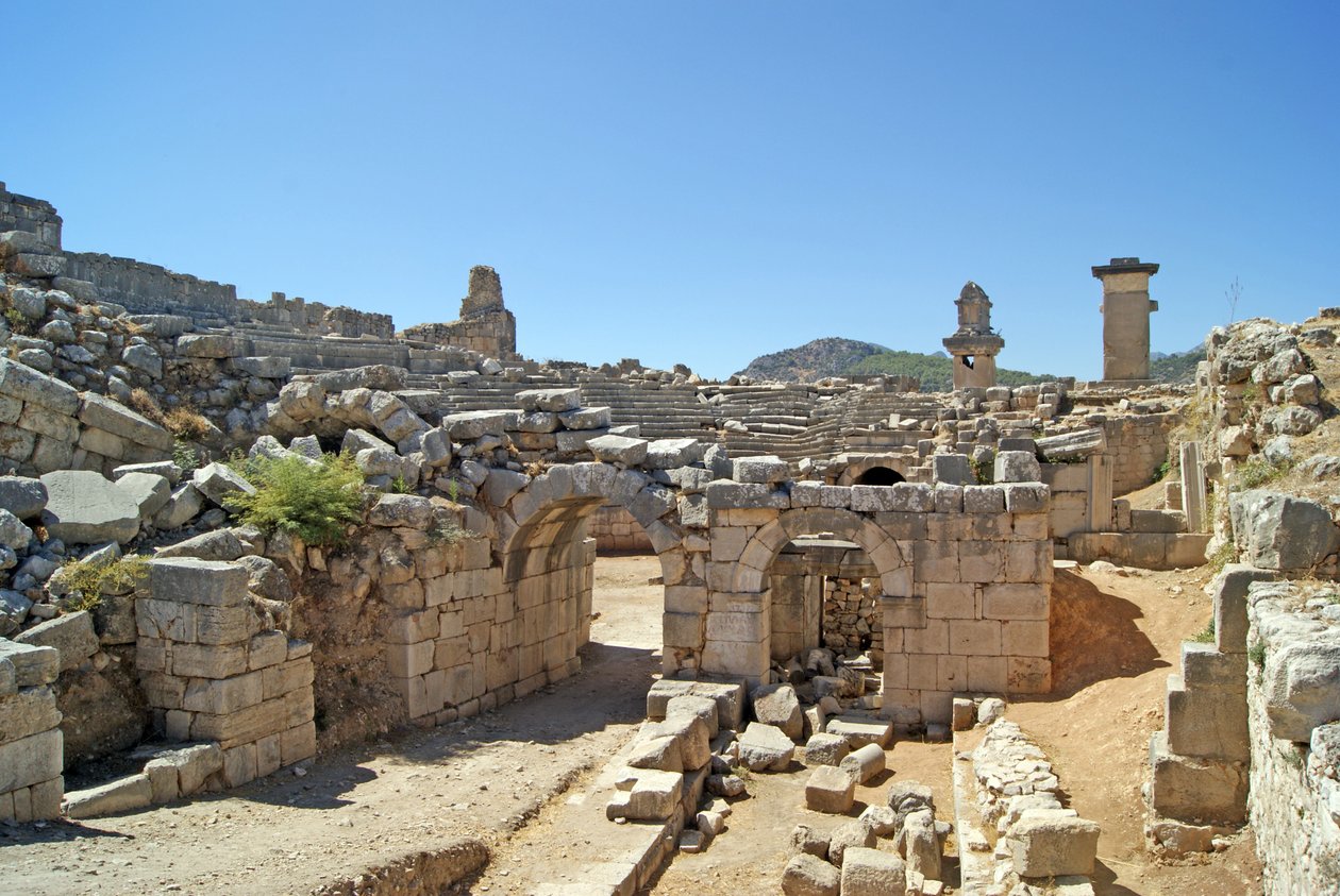 View through the vaulted entrance of the Xanthos theatre into the Orchestra pit, showing pillar and Harpy tomb, Xanthos, Turkey by Roman