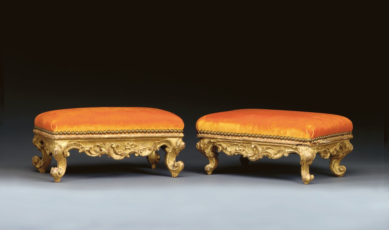 A matched pair of Italian rococo giltwood footstools by School Italian