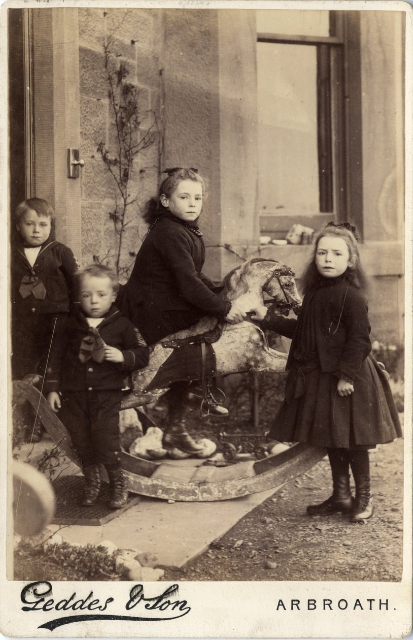 Group of young children and their rocking horse by Scottish Photographer