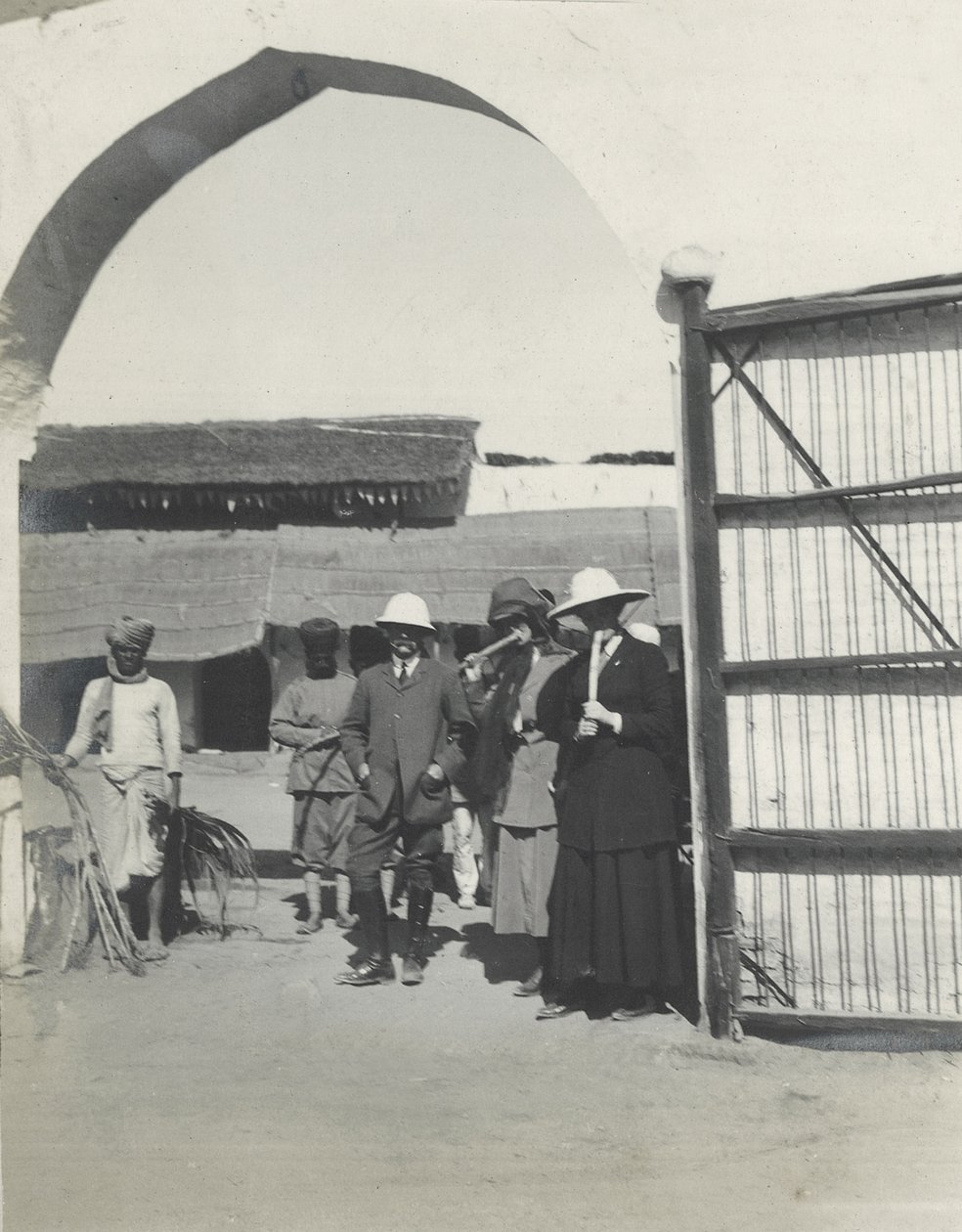 Major Gosling, Judy Smith and Lilah Wingfield smoking sugar cane at a police station near Fatehpur Sikri, January 1912 by Sylvia Brooke