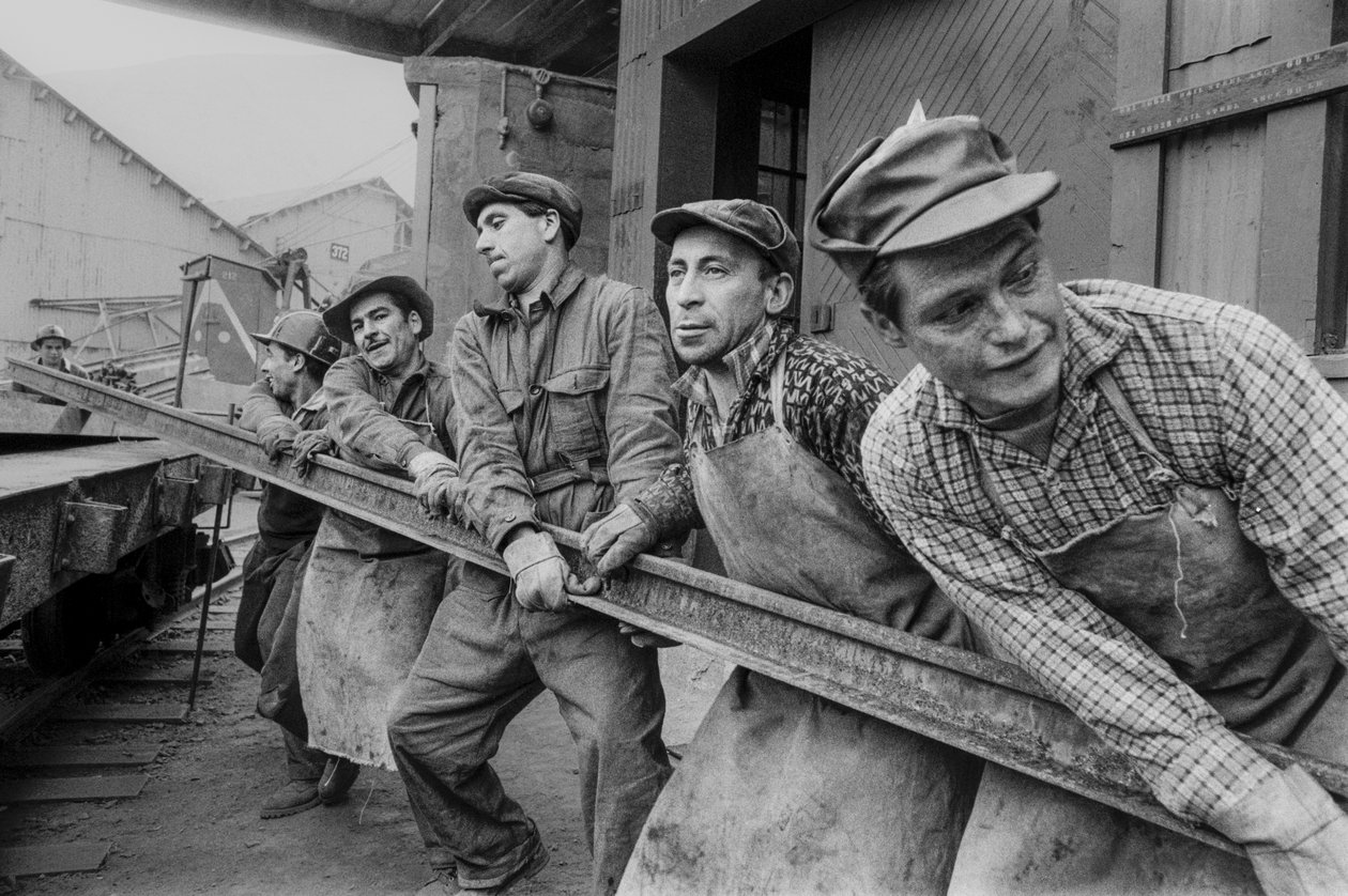 Mine workers pull together to move a heavy steel rail at El Teniente copper mine by Ted Spiegel