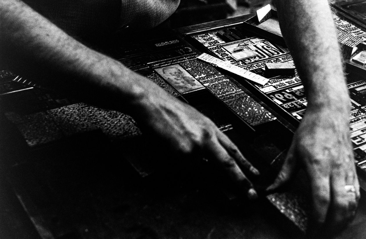Typesetter sets cold type from linotype machine for the Frontiersman newspaper by Ted Spiegel