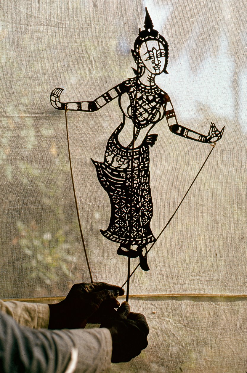 Puppeteer Manipulates Storytelling Shadow Puppet Against a Scrim for a ...
