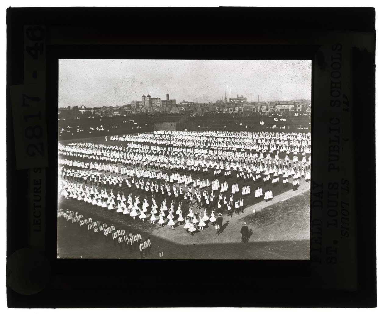 Horizontal, Black and White Photo of Hundreds of School Children Lined Up in Formation for Field Day Parade and Pageant. All the Girls in White Dresses and the Boys in White Shirts and Ties with Dark Pants by Unbekannt Unbekannt