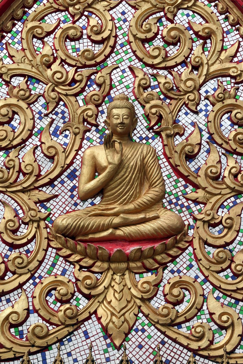 Entrance door ornamented with gold reliefs. The Teaching Buddha depicts a particular moment in the life of the Buddha, namely, the first sermon the Buddha gave after reaching Enlightenment, Vang Vieng, Laos by Unbekannt