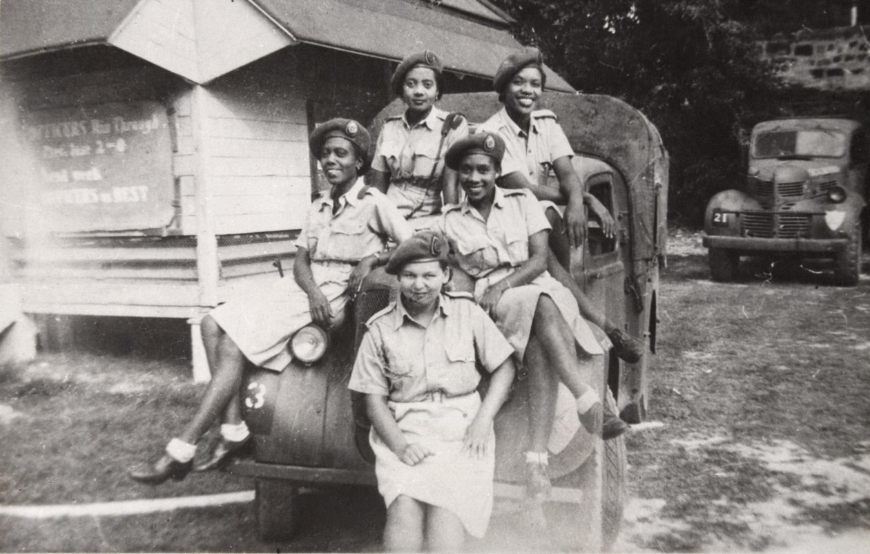 Five members of the West Indies Auxiliary Territorial Service sitting on a military vehicle by Unbekannt