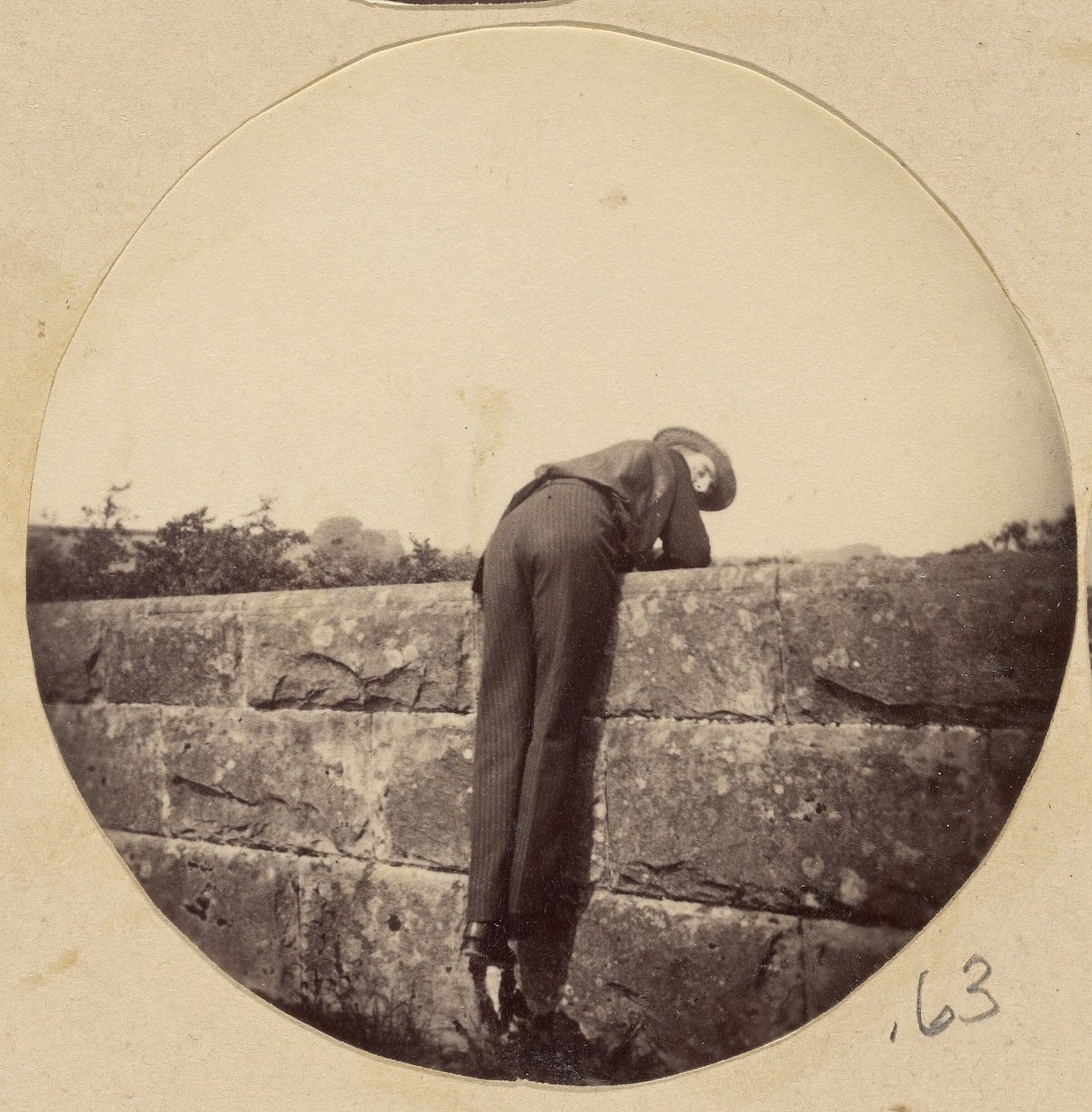 Man in Hat Bent Over a Stone Wall by Unknown artist