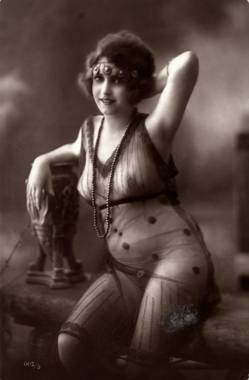 A young woman sitting down, wearing a transparent dress by Unknown photographer