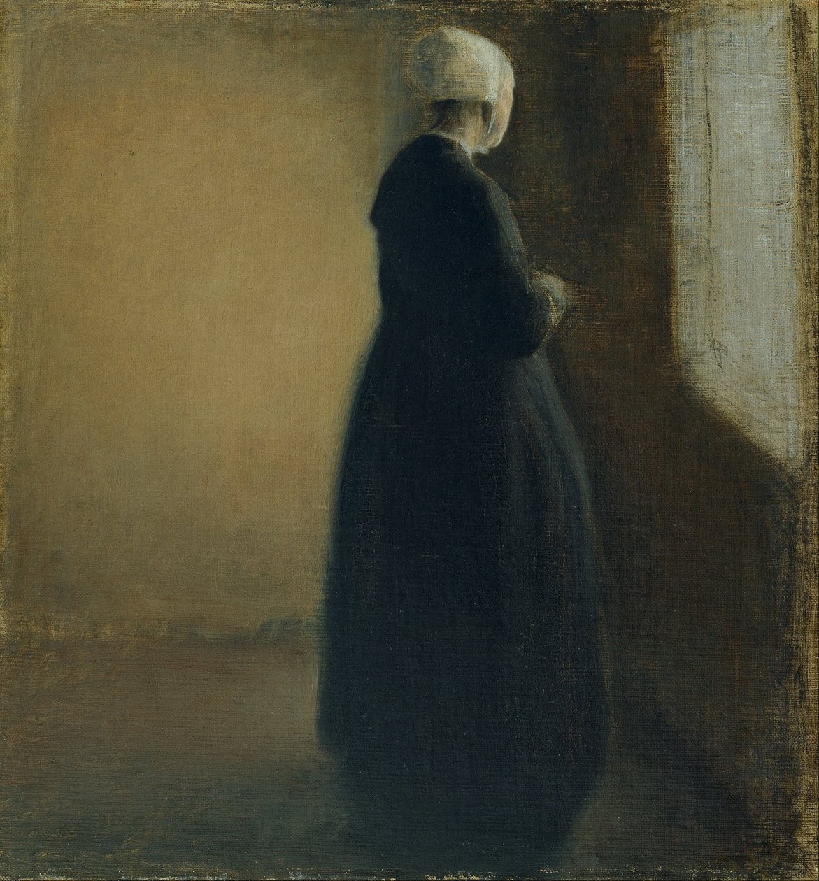 An old woman standing by a window by Vilhelm Hammershøi