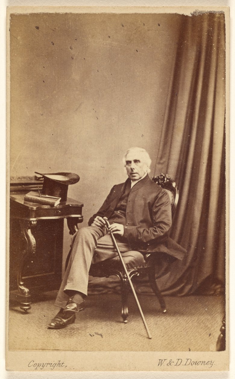 Unidentified White-Haired Man Seated, Holding a Cane, Top Hat and Book on Table at Left by W. and D. Downey