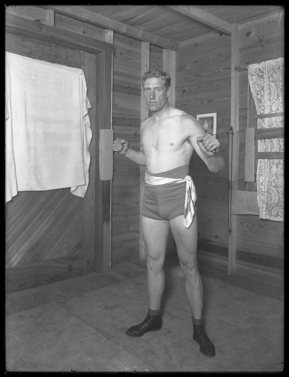 English Boxer William Thomas Wells (Bombardier Billy Wells), Posing in Training Togs with Weight Pulleys, c.1911 by William Davis Hassler