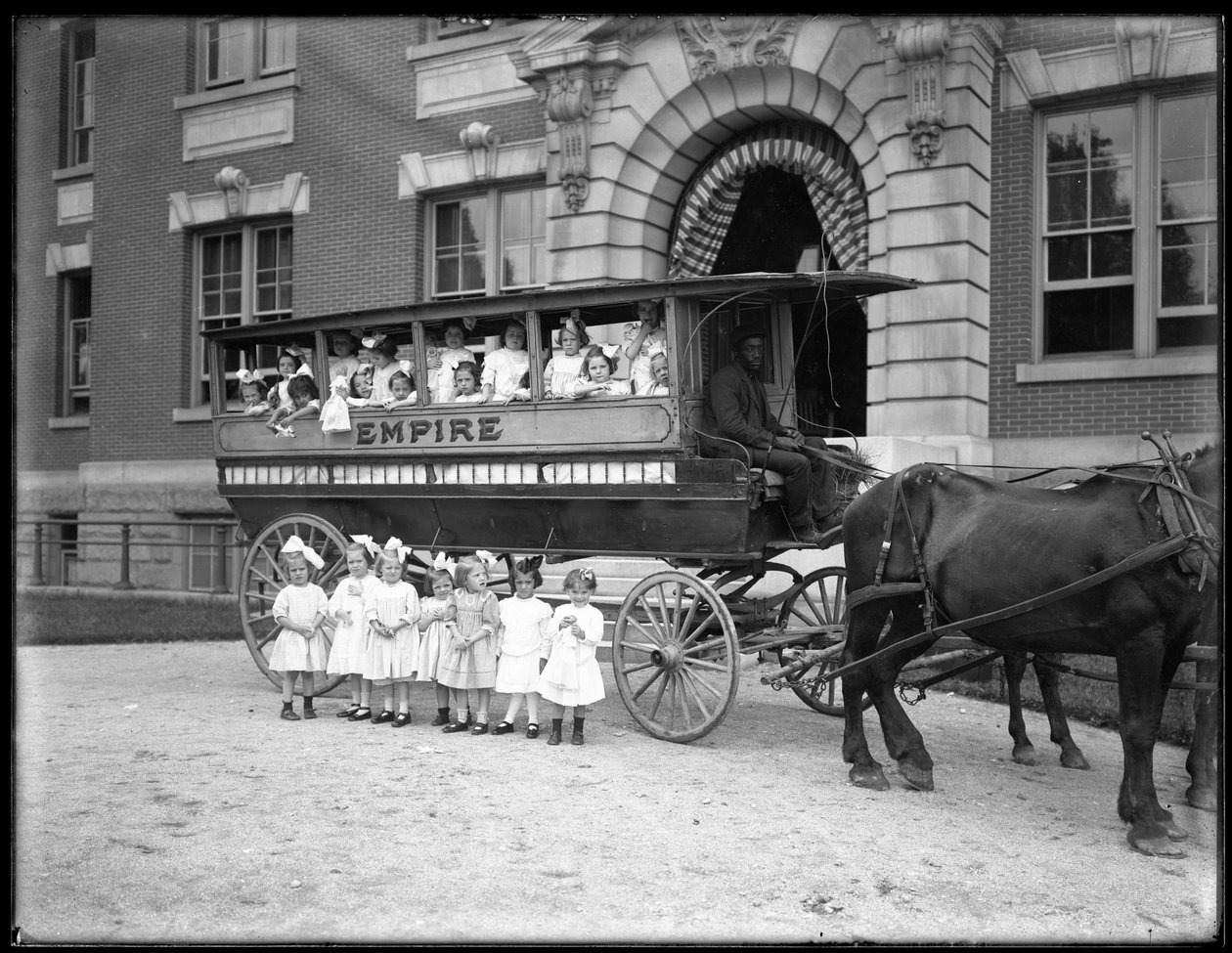 Small Girls Pose in and in Front of a Horse-Drawn Wagon, in Front of an Unidentified Building, Probably the Roman Catholic Orphan Asylum, Kingsbridge, Bronx by William Davis Hassler