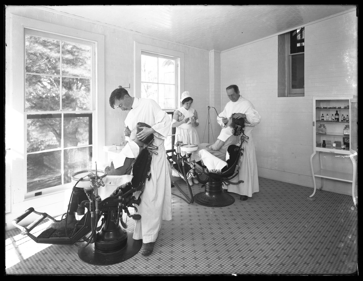 Two patients being examined, Dentist