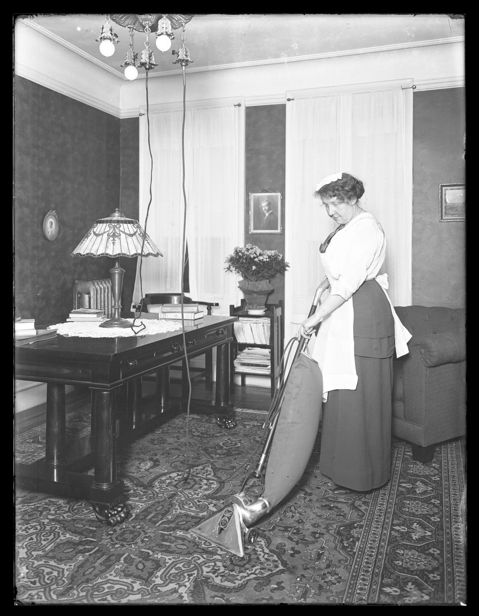Unidentified woman demonstrating the use of the Apex vacuum cleaner, c.1913-14 by William Davis Hassler