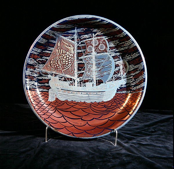 Charger with silver lustre, with a galleon sailing on a red lustre sea by William de Morgan