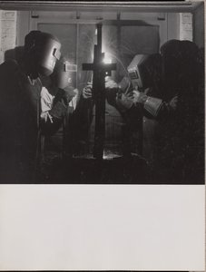 Four men wearing welding helmets welding a piece of metal by Arnold Eagle