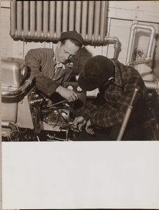 Two Men Work on a Machine Using a Screwdriver and a Wrench by Arnold Eagle