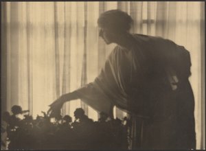 Woman Tending Flowers Inside Her Apartment by Arthur F. Kales