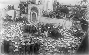 Seamen crowd around Australian Prime Minister William Morris (Billy) Hughes as he addresses them on the deck of HMAS Australia at the dockyard in Devon, England, 21 May 1916