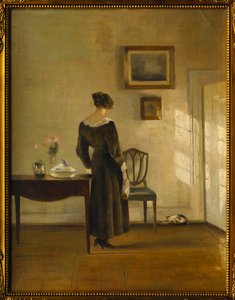 An Interior with a Woman feeding a Cat by Carl Holsoe