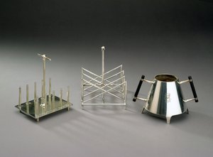 Toast rack with upright supports, manufactured by Hukin & Heath; triangular section toast rack, manufactured by Elkington & Co.; sugar bowl with ebonised wood