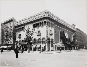 A huge theater with an elaborate facade, complete with Moorish arches and balconies. A large sign on top of the building reads 