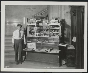 Blind news dealer, John Martie, at his stand at the south end of the Municipal Building, New York by Company Byron