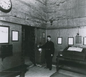 A Prison Warder Stands by a Door in the Entrance Hall by English Photographer