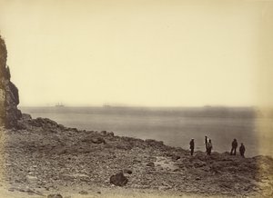 View of shore with ships on horizon and five figures standing on beach by Felice Beato