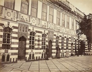 The courtyard of a Jewish house in Stambouli, Syria, Three domestics are shown near the walls of the building by Félix Bonfils