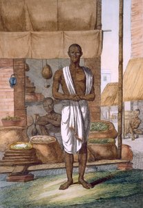 Grocer outside his shop with wares in sacks, from 