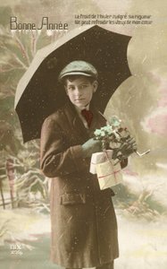 Handsome, well-dressed boy, standing in snow with umbrella