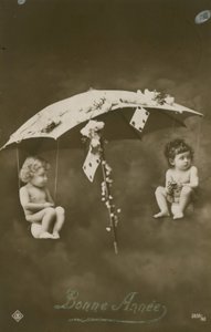 Happy New Year card with two babies hanging from an umbrella