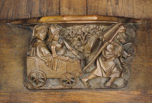 Carving depicting a couple in a cart pulled by a man, from a choir stall