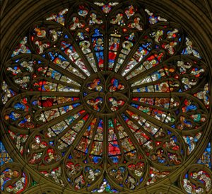 Window, the north rose window, depicting the Coronation of the Virgin in the two uppermost openings, surrounded by angels carrying musical instruments and the Instruments of the Passion by French School