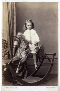 Young girl sitting on a rocking horse by George Washington Wilson