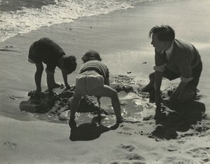 Three kids playing with sand at the beach by Godfrey Macdominic