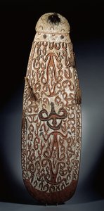 Oval Asmat shield, carved in relief with scrolling ornament incorporating highly stylised figures, plaited tassels to the border by Guinean New