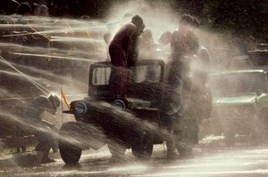 People are sprayed at the Water Festival during Buddhist New Year, Mandalay, Burma by James L Stanfield