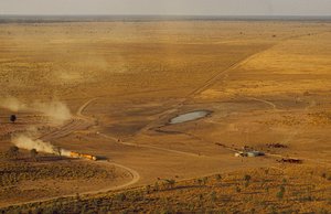 Road train carrying cattle crosses forbidding outback plateau, Western Australia by James L Stanfield