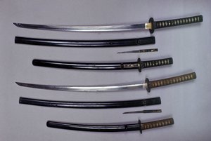 Top: a katana, Japanese sword and its sheath, wakizashi, Japanese short sword in its sheath, small Kokatawa dagger stows in the same scabbard. All three are from the 18th century. The lower ones are from the 17th century by Japanese School