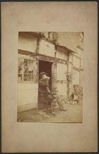 Seated man drinking from mug in open doorway