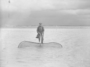 Fisherman Using a Large Net in Shallow Water
