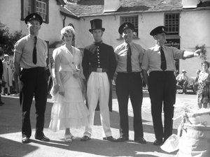 Men and women in fancy dress at Hawkshead Fayre standing in front of Minstrel